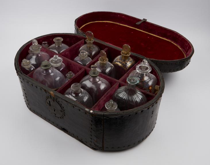 Oval, brass-studded leather covered medicine chest