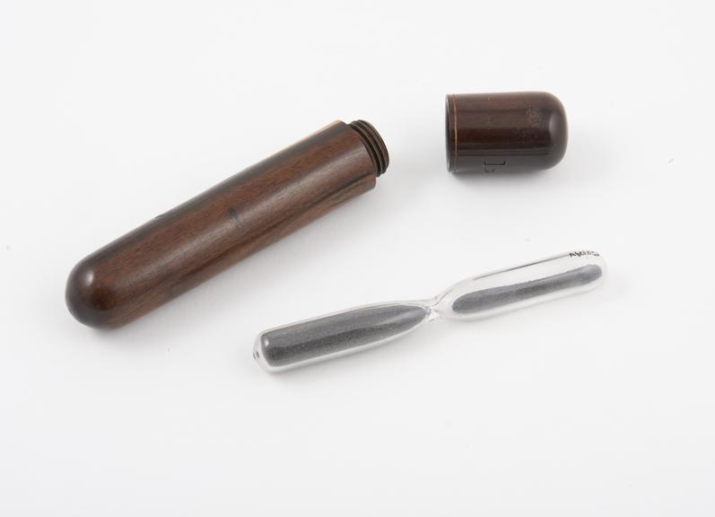 Pulse glass, with grey powder, in wooden case