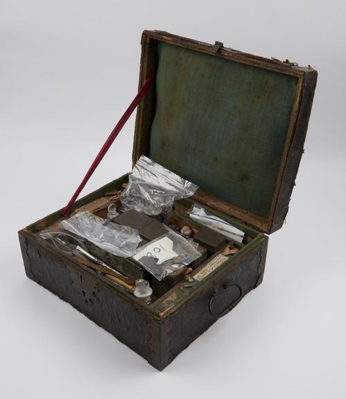 Medicine chest of leather covered wood, with 13 glass bottles