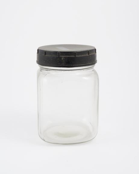 An empty glass jar used to house pathology specimens at