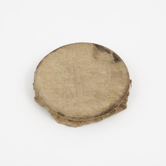 Rim of glass drug jar with parchment cover