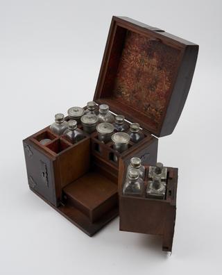 Wooden triptych medicine chest with handle and decorative fittings with contents