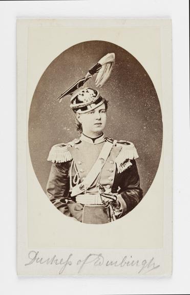 A Carte de visite portrait of a woman in military dress by an