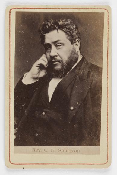 A Carte de visite portrait of a bearded man resting his head on