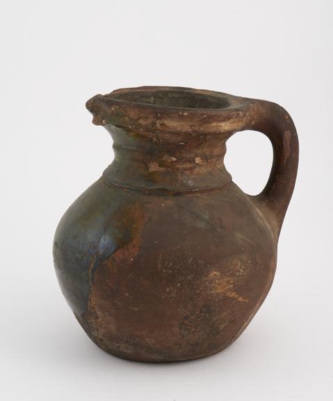 Thick terracotta Elizabethan jug, green glazed on front only