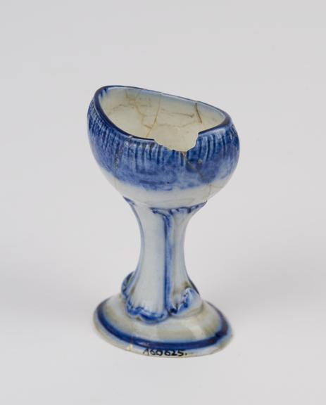 Earthenware eye bath, with ornamental moulded stem, English