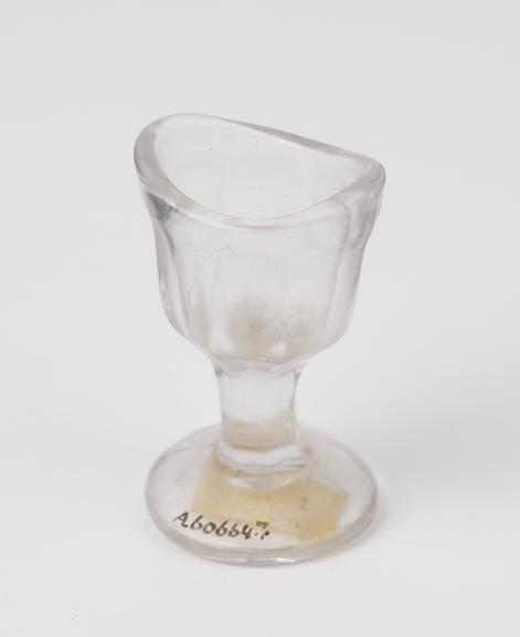 Glass eye bath, with fluted stem and bowl, moulded