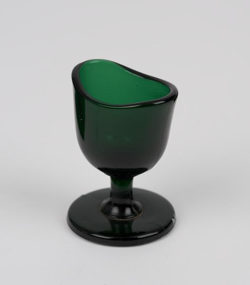 Green glass eye bath, with stem, probably English