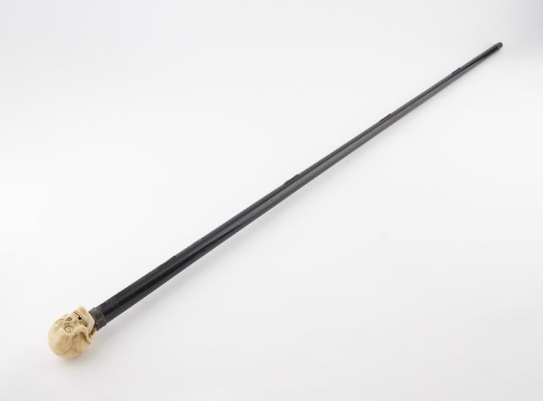 Ebonised walking stick with silver collar and ivory skull for