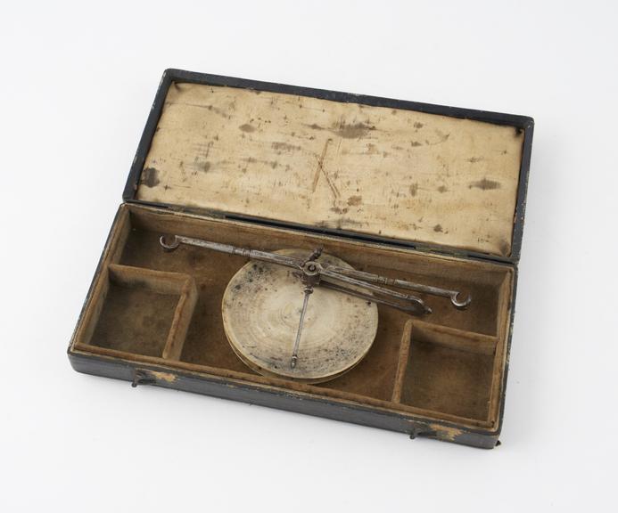 A steel beam and 2 ivory pans from an apothecary's balance in leatherette case