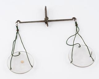 Apothecary's balance with steel beam and glass pans suspended from green silk cords