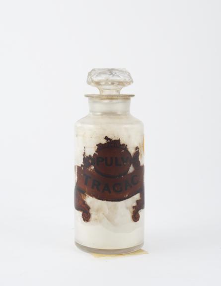 Bottle, clear glass, with contents, for powdered tragacanth