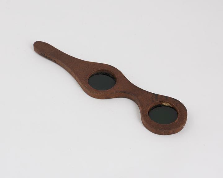 Two green lenses set in a wooden holder