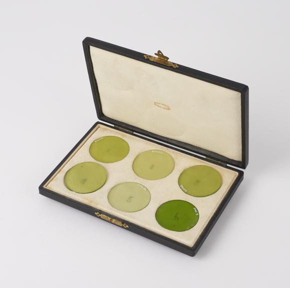 Set of six green glass filters, in original case