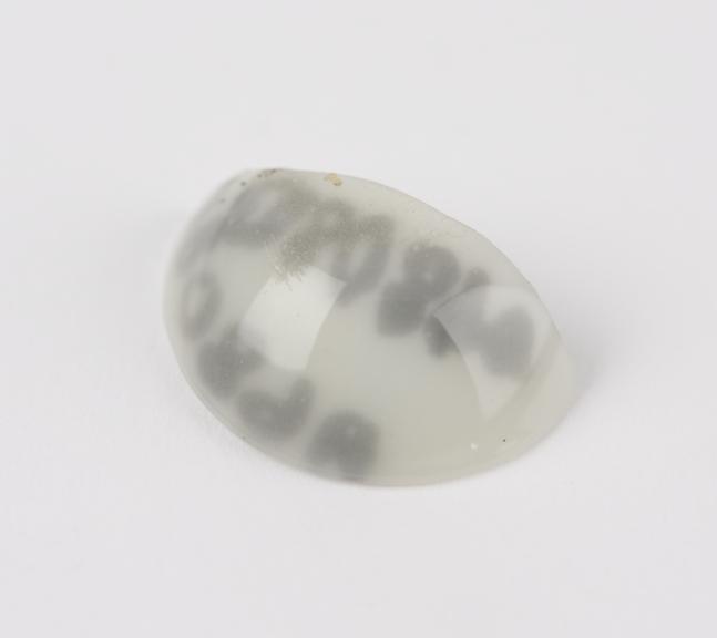 Semi-circular piece of white glass, part of an artificial eye