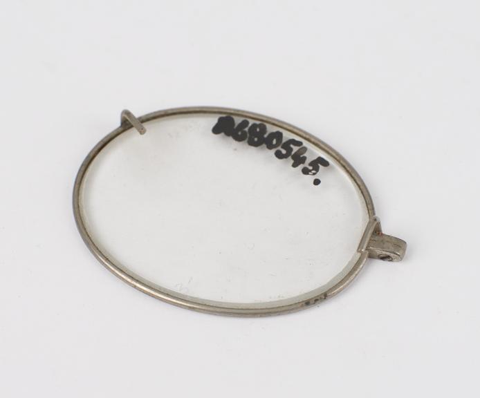 Oval trial lens in nickel plated(?) rim with hooks