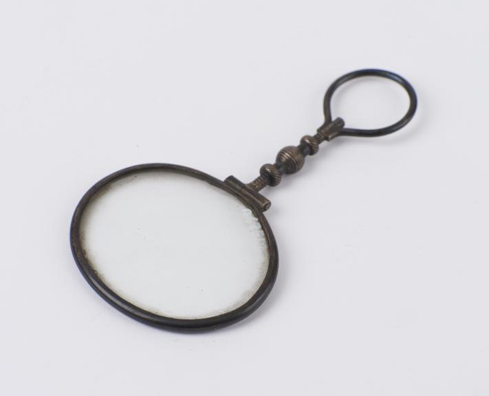 Oval magnifying glass in silver frame with twisted handle