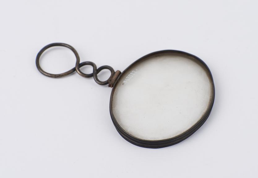 Oval magnifying glass in silver frame with twisted loop handle