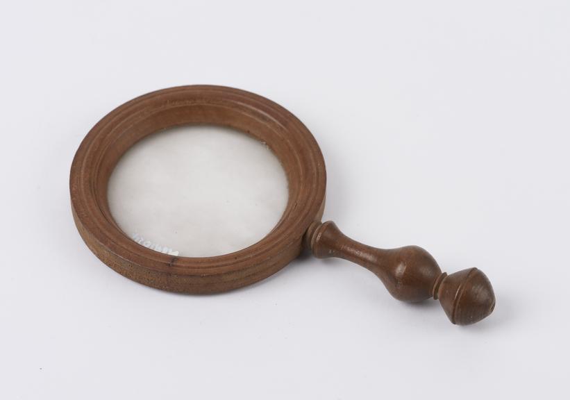 Magnifying glass set in nicely carved wooden frame