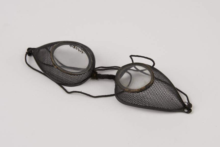 Pair of metal rimmed oval spectacles, with wire mesh protectors