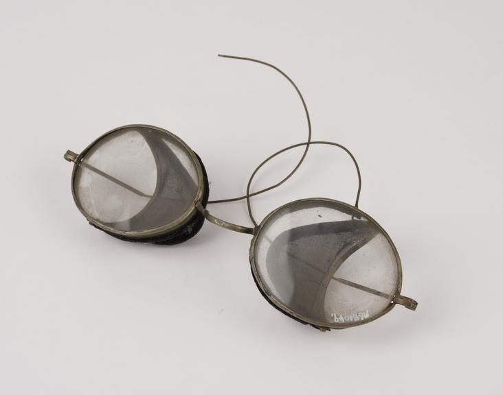 Pair of oval metal-rimmed spectacles with hinged wire mesh