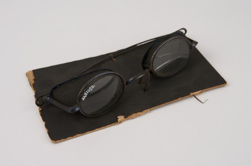 Pair of oval metal-rimmed spectacles with wire-mesh shields