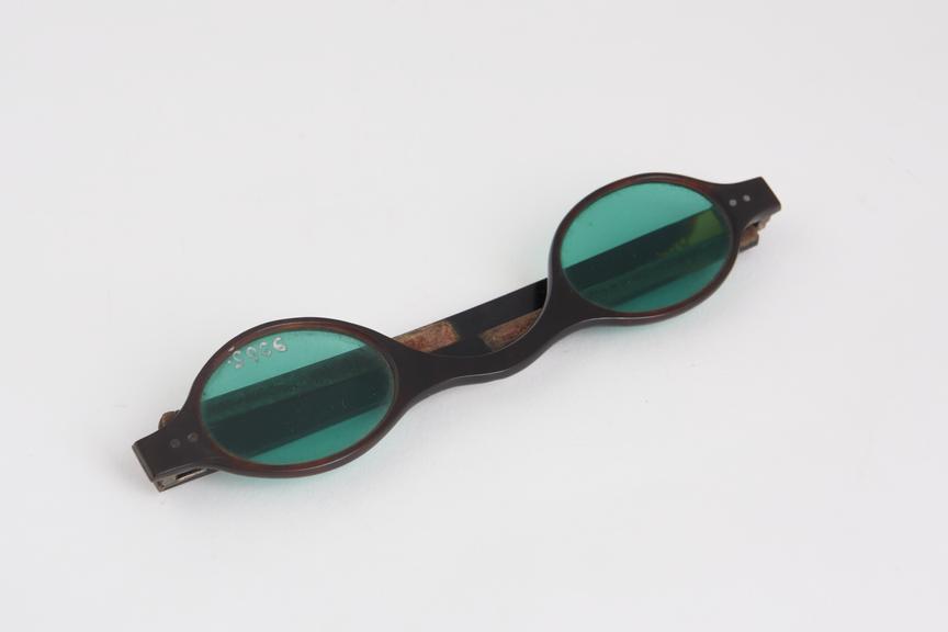 Straight spectacles, tortoiseshell frames, lenses tinted green