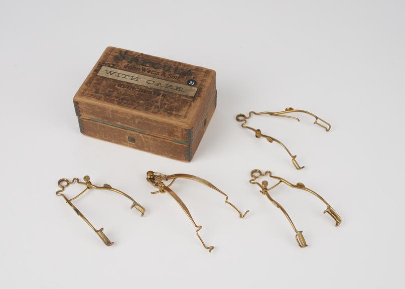 Set of 4 ophthalmic speculae, metal, gilt, in cardboard box