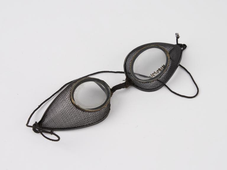 Pair of metal rimmed oval spectacles, with wire mesh protectors