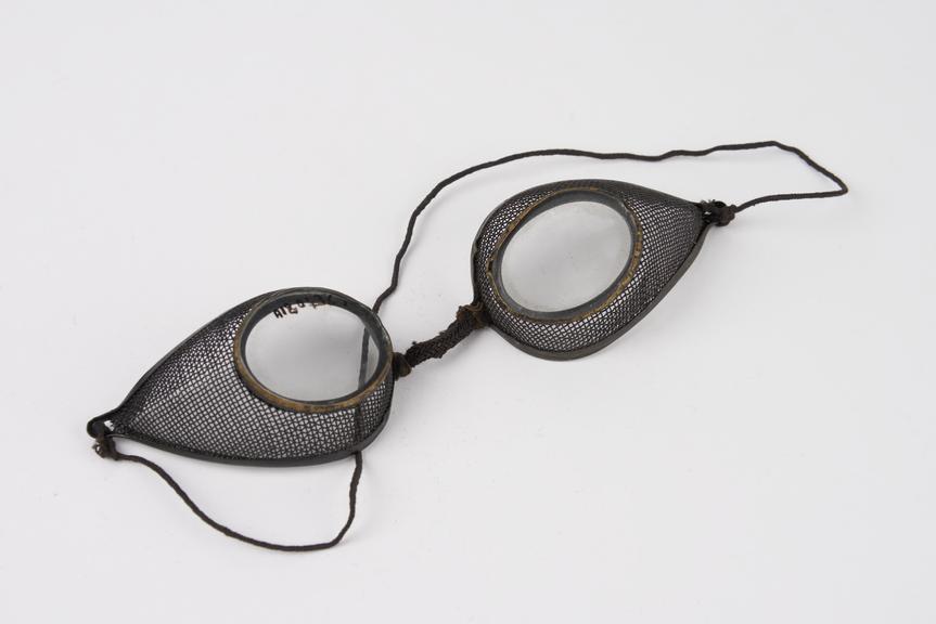 Pair of metal rimmed oval spectacles, with wire mesh protectors