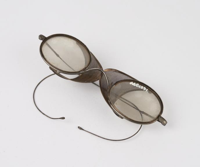 Pair of oval steel-rimmed spectacles with hinged wire mesh