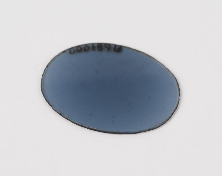 Lens, oval, flat, smoky-blue tinted, from spectacles, European