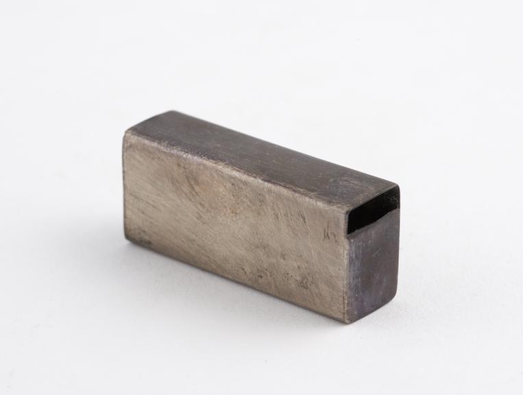 Rectangular silver box, possibly the cap from a toothbrush set