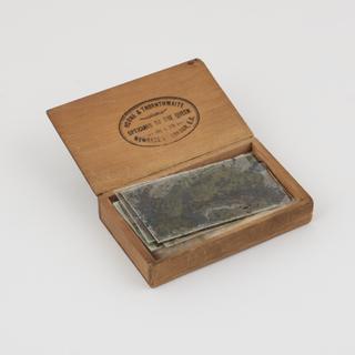 Box containing sheets of photographic negatives and glass
