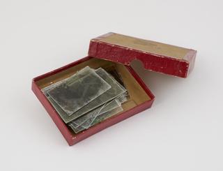 Box containing sheets of photographic negatives and glass