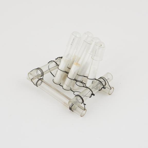 Set of 6 test tubes, each with a glass cap set upright in a