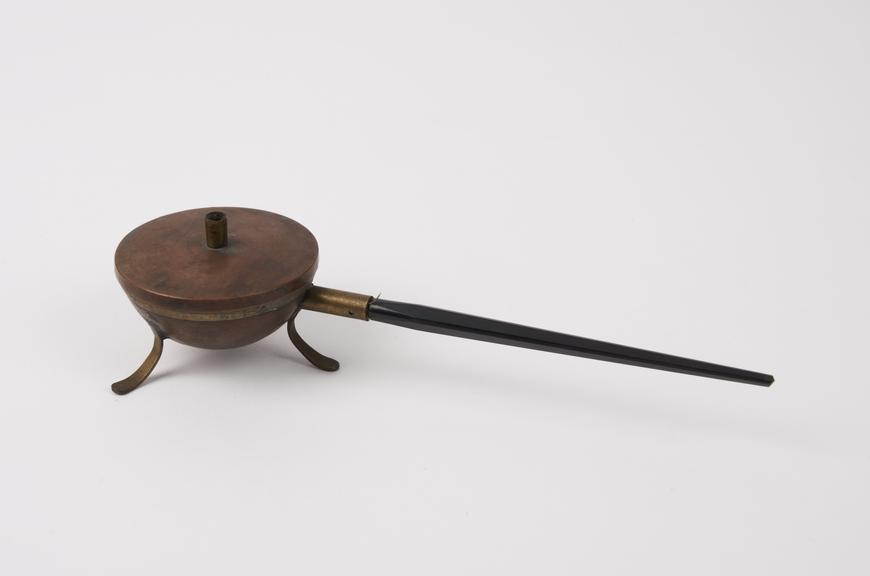 Small copper cauldron, on ebony (?), handle, brass feet