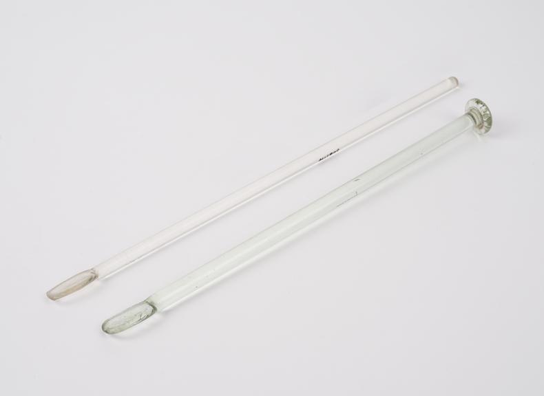 Two clear glass rods, spatulate at one end, one has button base