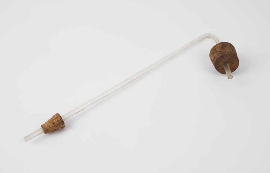 Clear glass tube bent downwards at one end with cork stoppers