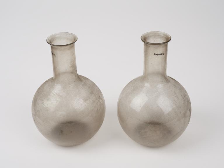 Two clear glass flasks with spherical bodies and tubular necks