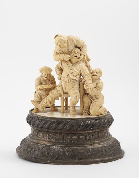 Ivory figure group, depicting a tooth extraction