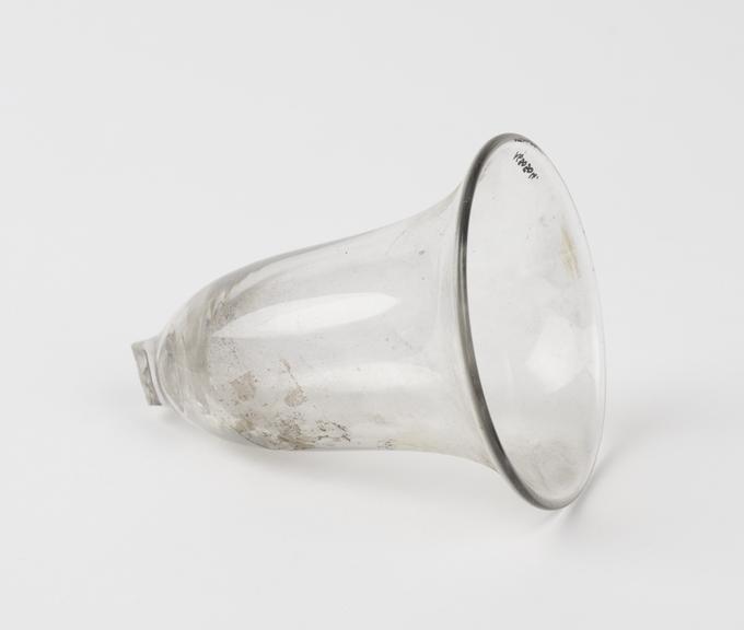 Clear glass vessel in the shape of a bell, with broken grip