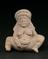 Hollow unglazed terracotta female fertility figure squatting