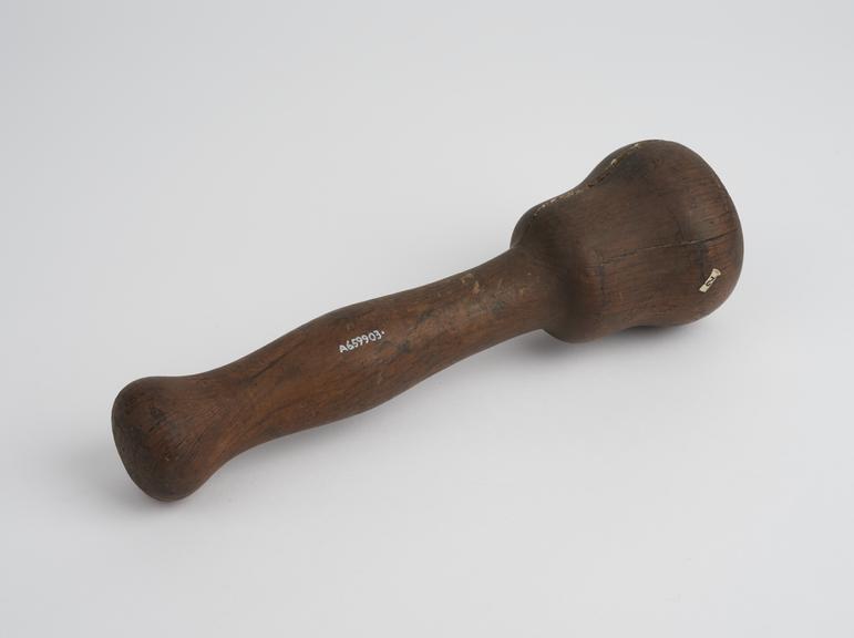 Turned wooden pounder with bell-shaped pounding en