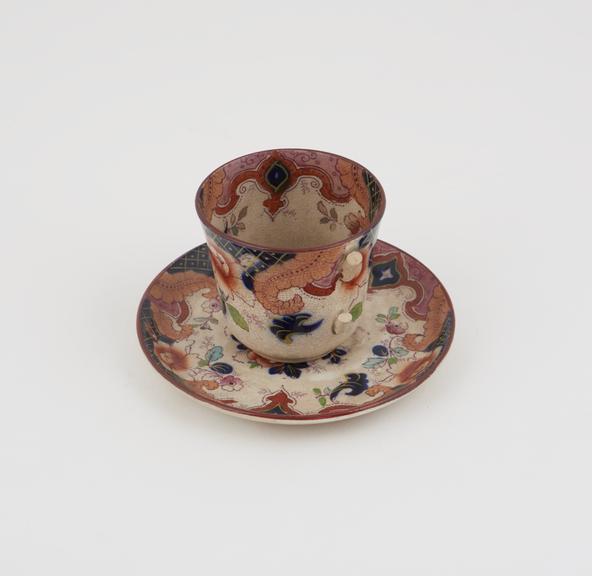 Creamware cup and saucer, with blue and red design