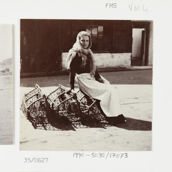 Photograph of a woman sitting on some crab pots at Whitby