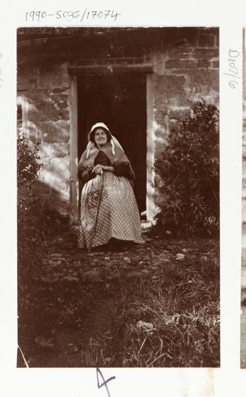 Photograph of a woman sat in a doorway in Whitby