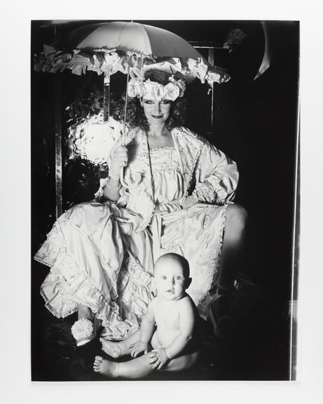 Photographic print of a woman in a rose headdress with a baby at her feet