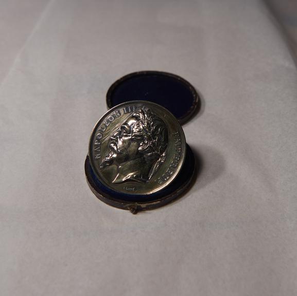 Gold-Coloured Circular Metal Medal, in Blue Circular Case, Won by James Moore