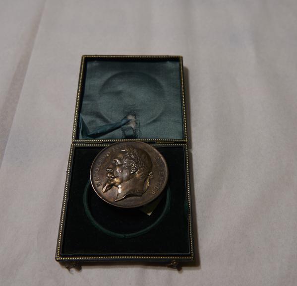 Gold-Coloured Circular Metal Medal, in Green Square Case, Won by James Moore